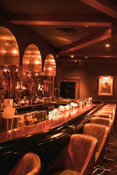 a dimly lit bar with chairs and lights