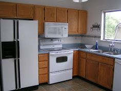 a kitchen with wooden cabinets and white appliances