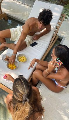 three people sitting at a table with plates of food