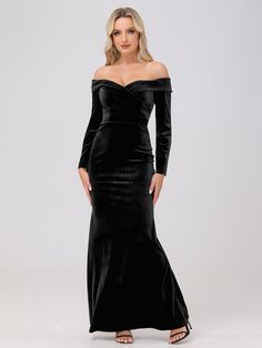 a woman wearing a black velvet gown with long sleeves and an off the shoulder neckline