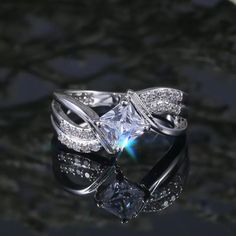 a white gold ring with a princess cut diamond