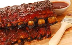 two ribs on a wooden cutting board with sauce