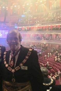 two men standing next to each other in front of an auditorium filled with people and lights