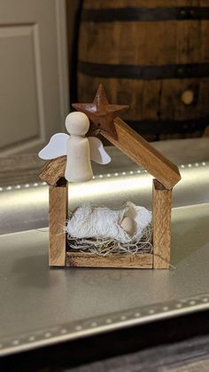 a small wooden nativity scene with a star on the top and sheep in it