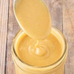 a spoon full of peanut butter on top of a jar