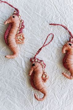 three seahorse ornaments are hanging on the wall