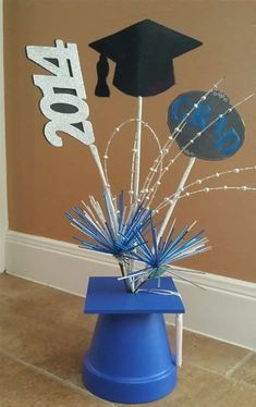 an image of graduation decorations on the floor with balloons and streamers in blue bucket