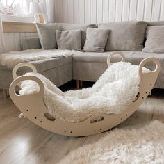 a wooden sleigh bed with white fur on the floor next to a couch