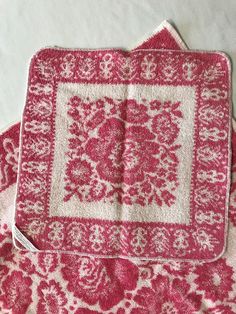 two pink and white placemats sitting on top of each other