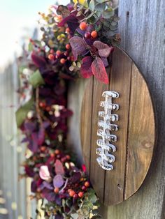 a football wreath hanging on the side of a wooden fence