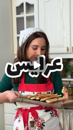 a woman in an apron holding a tray with food on it and the words arabic above her