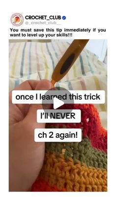 someone is crocheting on their bed with the help of an orange handled crochet hook