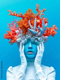 a woman with blue paint and corals on her head is holding her hands to her face