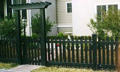 a black fence in front of a white house