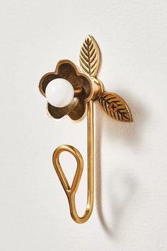 a gold metal hook with a flower on it