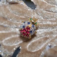 A Ladies 18K Yellow Gold Lucky Ladybug Pin By LeVian Set With 12 Round Diamonds Having A Total Approximate Weight Of .18 Carats, 10 - 2.5 Mm Round Rubies, 8 - 1.7 Mm Round Sapphires, And 2 - 1.3 Mm Round Cabochon Emerald Eyes. The Pin Measures 5/8 Inch In Length And Can Also Be Worn As A Pendant. This LeVian Pin Is Circa 1980 And Has Inventory Number 1270. Lucky Ladybug, Vintage Jewelry Antique, Emerald Eyes, Round Sapphire, Jewelry Antique, Treasure Chest, Mens Accessories Fashion, Estate Jewelry, Citrine