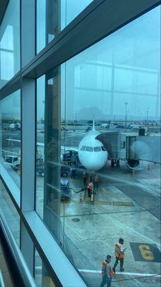 an airplane is parked at the airport with people standing around it looking out the window