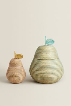 two small baskets one with a handle and the other with a stick sticking out of it