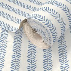 a blue and white wallpaper with leaf designs on it's side, next to a roll of paper