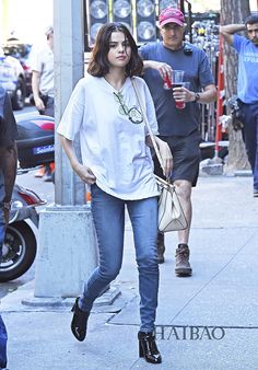 a woman is walking down the street with her hand in her pocket