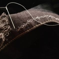 an old pair of jeans that have been stitched together with some thread on them