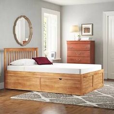 a bedroom with a bed, dresser and mirror