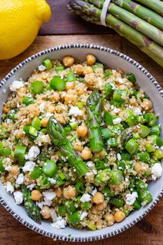 asparagus, chickpeas and feta salad in a bowl with lemons on the side