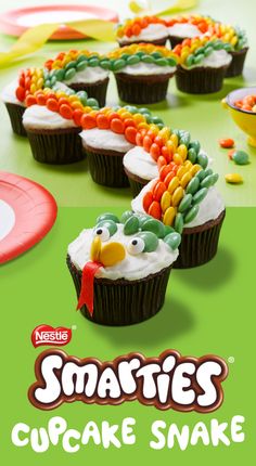 some cupcakes with frosting and candy on them in the shape of a bird