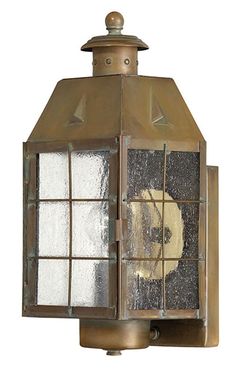 an old - fashioned wall light with frosted glass panels and metal fittings on the top