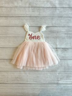 "♥ Product Information 100% Cotton in bodice and lining 100 % polyester tulle skirt Do not bleach Color is an Off White for the top and light pink for the tutu. Bunny age one is a rose gold color on the dress. Toddler tutu dress 's elastic back has a small loop to tie the strap crossover, adjust the length accordingly for a comfortable fit Beautiful baby dress has 4 layers exquisite fine tulle on the skirt with cotton lining to protect toddler girls gentle skin; Double layer front bodice with sw Some Bunny Is One Outfit, Easter First Birthday Girl, Some Bunny Is One Cake Smash, White Dress For First Birthday And Easter, Some Bunny Is Turning One Cake, Some Bunny Is Turning One Decorations, White Easter Dress For First Birthday, Bunny Smash Cake, Bunny First Birthday Girl