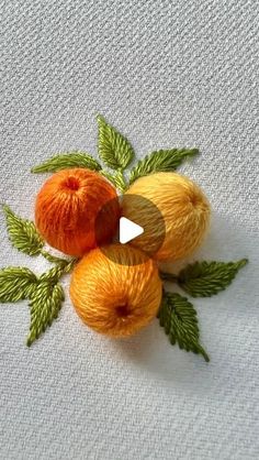 three balls of yarn sitting next to each other on top of a white table cloth