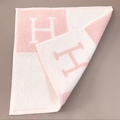 two towels on top of each other with the letters h and t printed on them