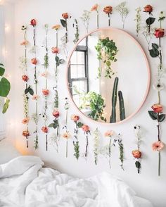 a bedroom with flowers on the wall and a round mirror