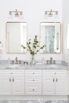 a bathroom with double sinks and two mirrors on the wall next to eachother