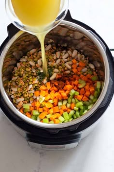 a pot full of vegetables being poured into it with a glass in the bottom left corner