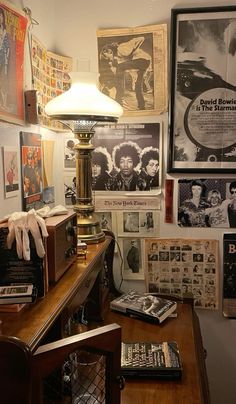 a room filled with lots of posters on the wall and a lamp next to it