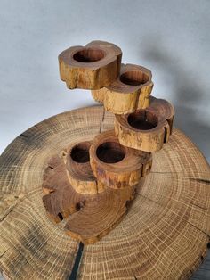 four wooden candlesticks sitting on top of a piece of wood