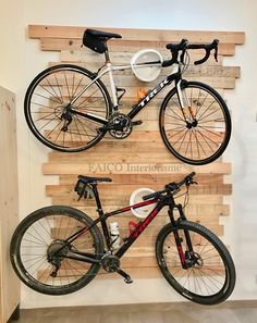 two bikes mounted to the side of a wooden wall in a bike shop, one is white and the other is black