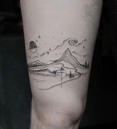 a man's arm with a mountain and stars tattoo on the left side of his leg