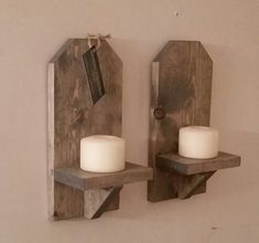 two wooden wall sconces with candles on them