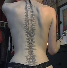 the back of a woman's body with an intricate design on it