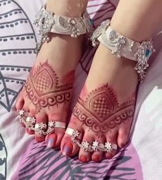 a woman's feet with henna tattoos on them