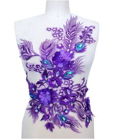 a mannequin with purple flowers and peacocks on it's back side