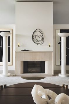 a living room filled with furniture and a fire place in front of a white wall