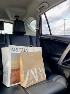 two bags sitting in the back seat of a car, next to a magazine bag