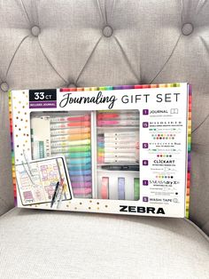 the zebra journal gift set is sitting on a chair with it's contents in its box