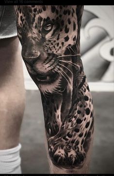 a black and white tattoo of a leopard on the leg