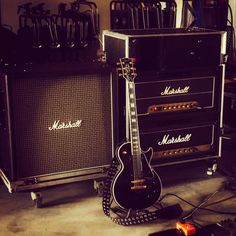 an electric guitar sitting next to two amps