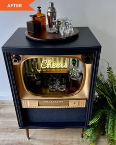 an old tv turned into a bar cart with liquor bottles and glasses on the top