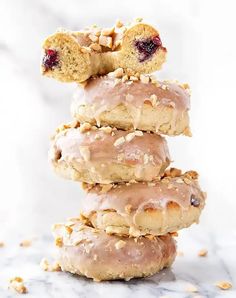 a stack of doughnuts covered in icing and nuts